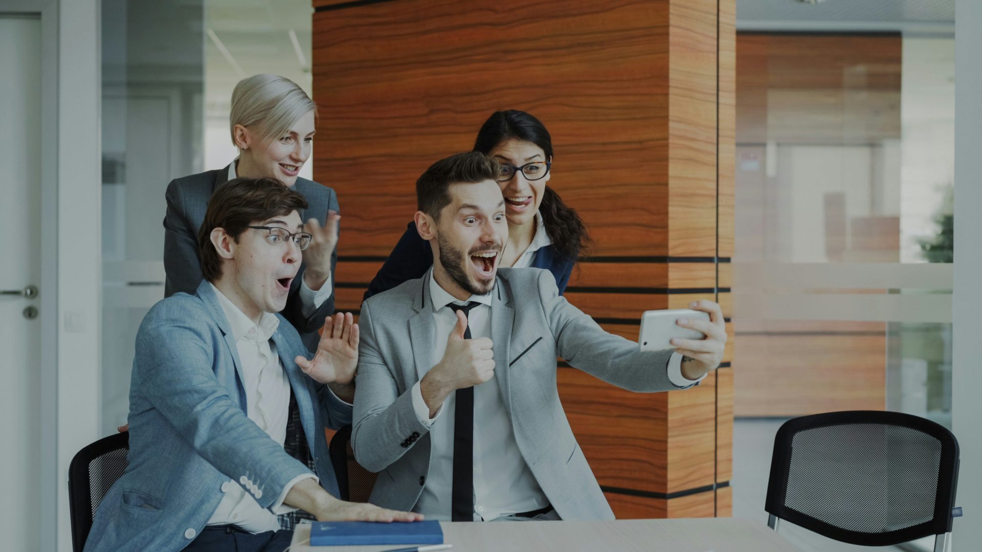Das Team feiert einen Erfolg, während es ein Selfie macht.