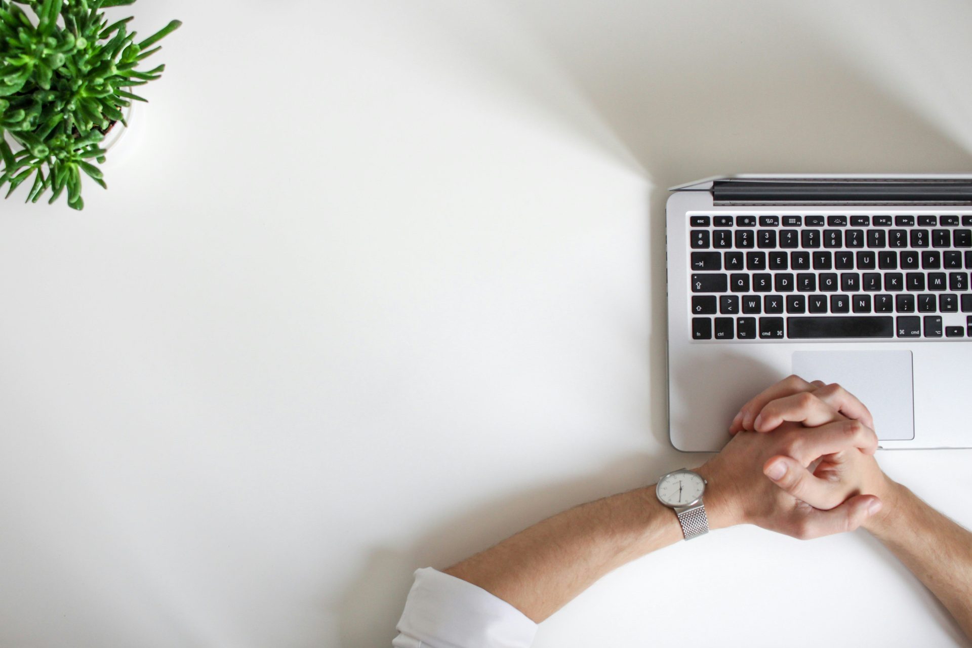 Person mit Armbanduhr am Laptop